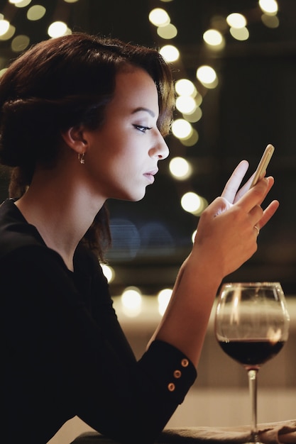 Woman in restaurant using the smartphone