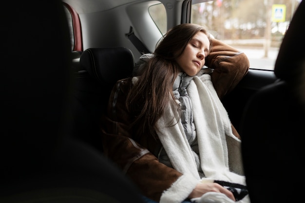 Free photo woman resting in the car while on a winter road trip