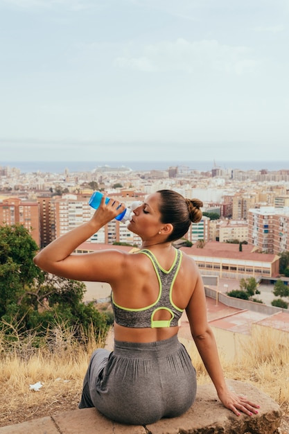 Woman resting and drinking after sport