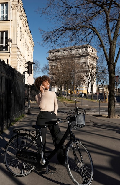 Free Photo woman riding the bike and talking on the smartphone in the city in france