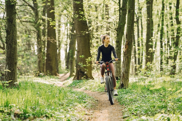 Woman riding a mountain bike in the forest