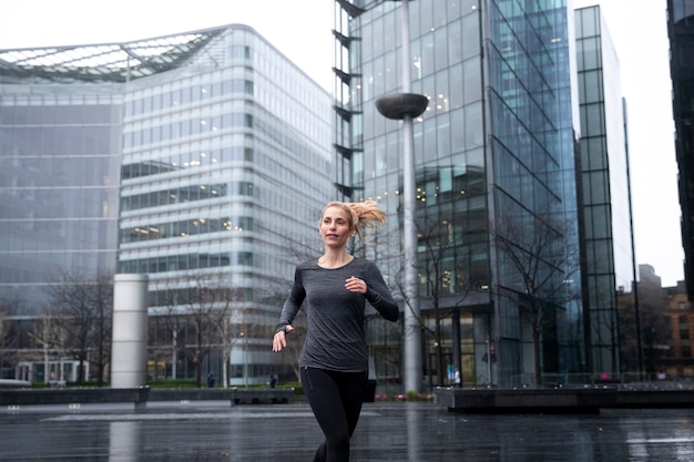 Woman running and doing her exercises outside while it rains