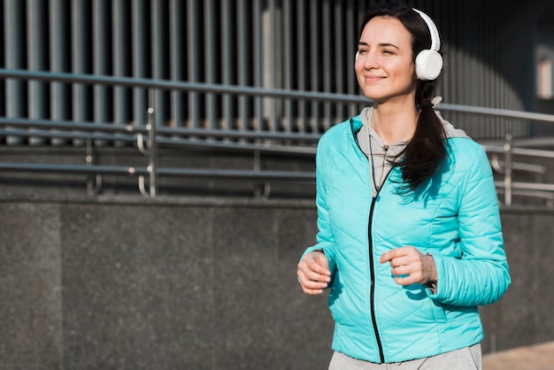 Woman running while listening to music through headphones