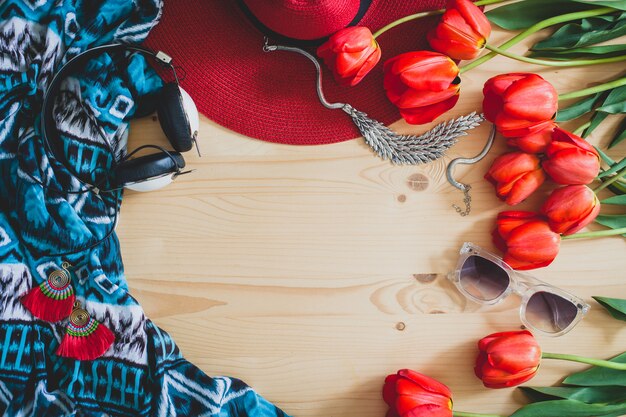 Woman's accessories and red tulips on table