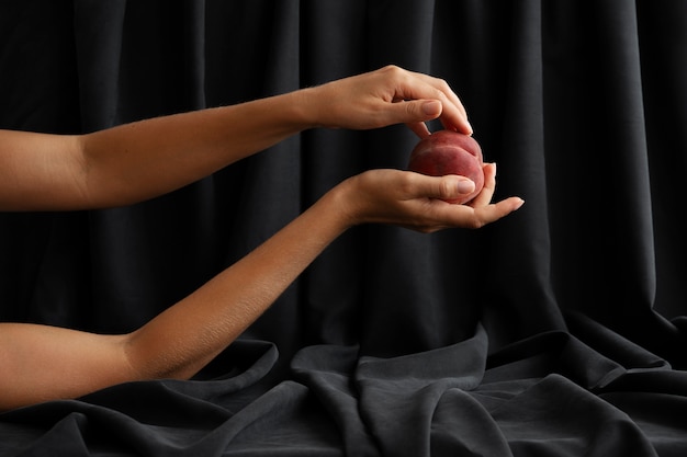 Free photo woman's arms posing with peach