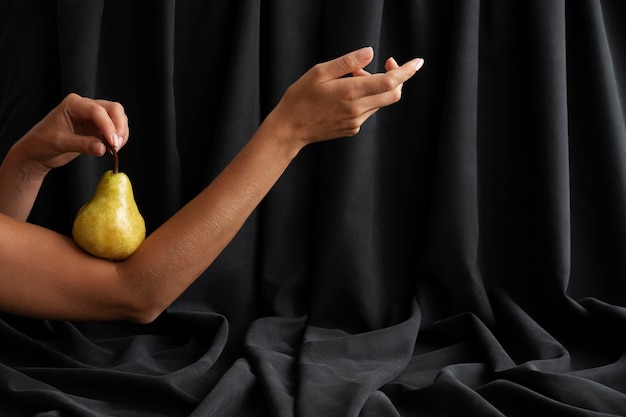 Free photo woman's arms posing with pear