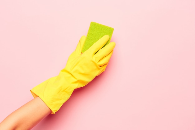 Free photo the woman's hand cleaning on a pink wall. cleaning or housekeeping concept