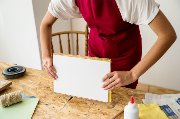 Woman's hand holding mold over wooden desk