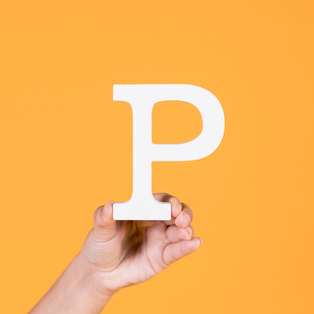 Woman's hand holding the white letter p