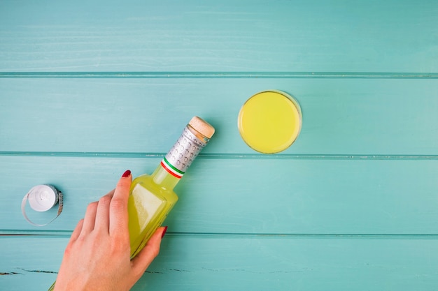 Woman's hand holding yellow juice bottle