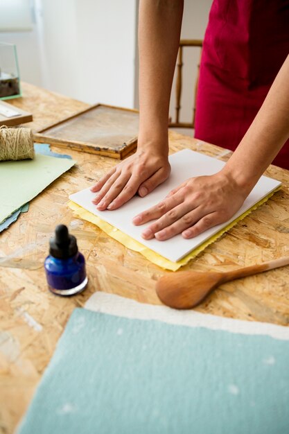 Woman's hand pressing mold for making paper