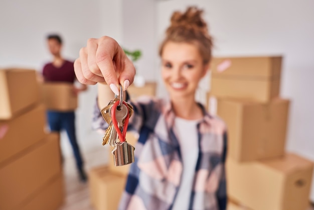 Free photo woman's hand showing keys from new apartment