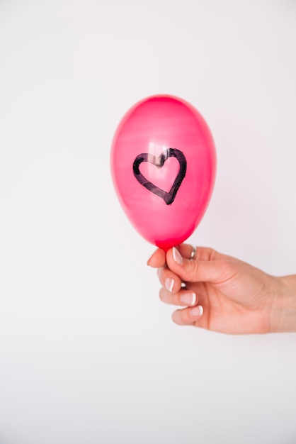 Free photo woman's hand with balloon with painted heart