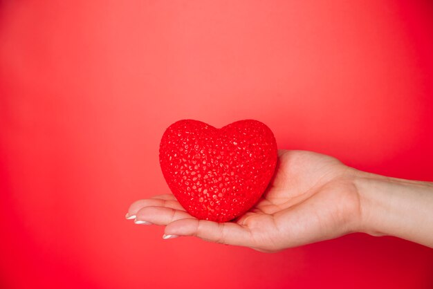 Woman's hand with red decorative heart