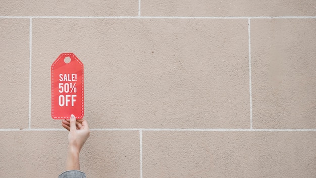 Free photo woman's hand with red sale sign