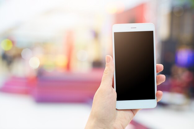 Woman's hands holds modern electronic gadget. Unrecognizable female with white mobile phone