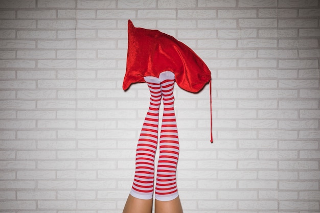 Free Photo woman's legs in stockings with red sack 