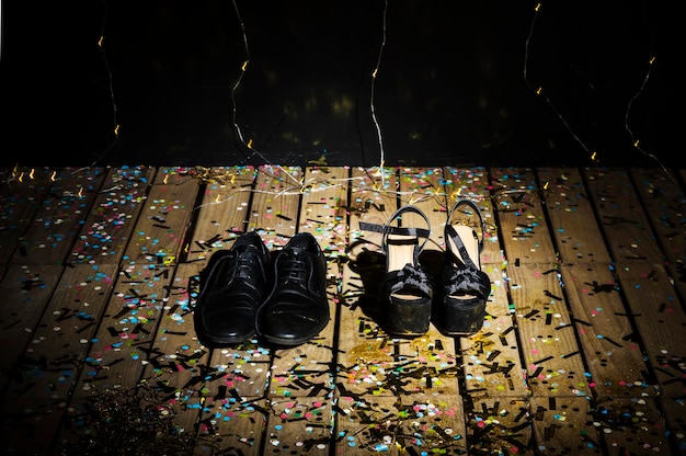 Free photo woman's shoes and man's boots between confetti