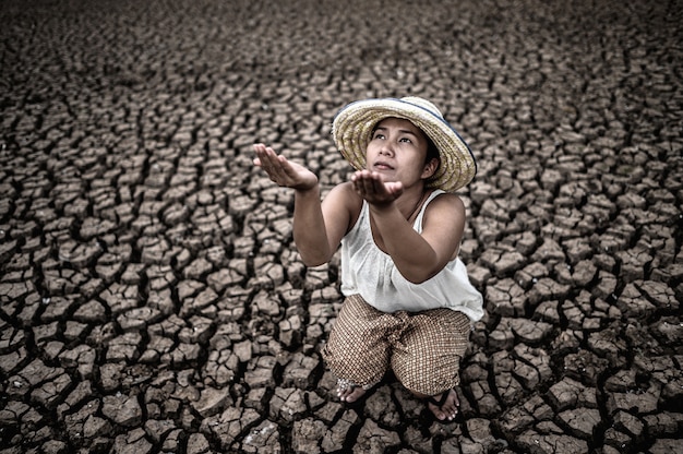 Free photo the woman sat looking at the sky and asked for rain in the dry weather, global warming