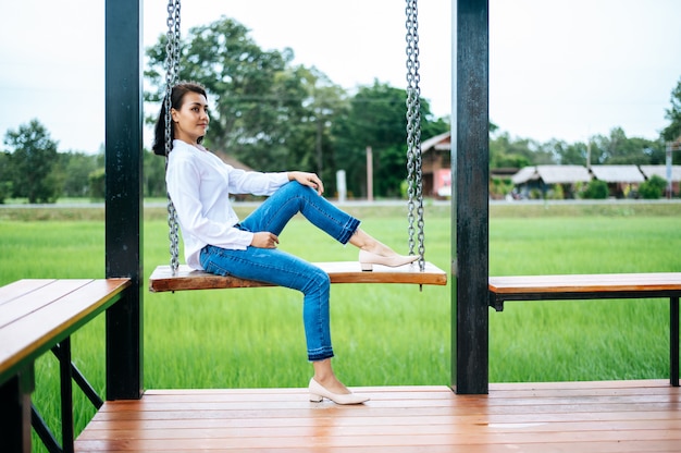 Free photo woman sat on the swing and laid her hands on her knees