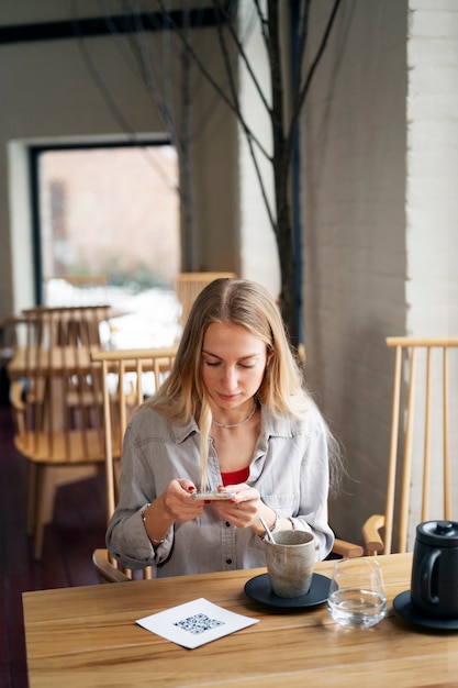 Woman scanning qr code at restaurant