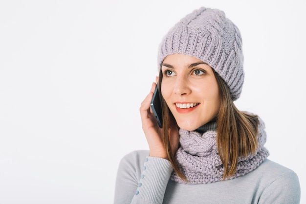 Woman in scarf and hat speaking on phone