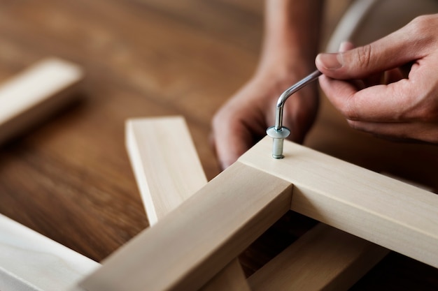 Free photo woman screwing in chair’s nail for ready-to-assemble furniture