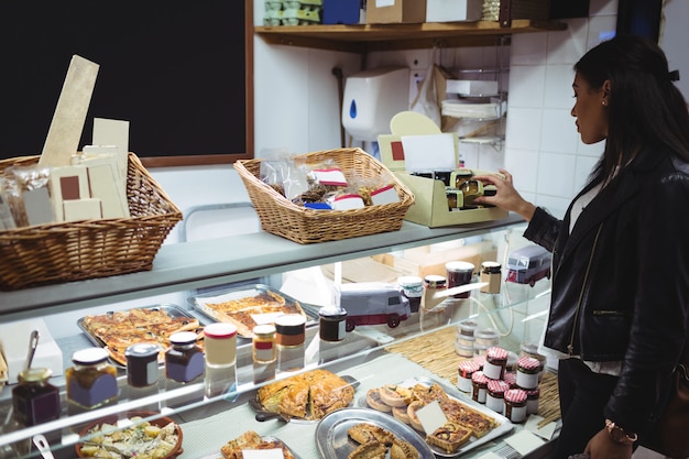 Free photo woman selecting packed food at food counter