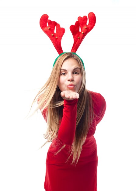 Woman sending a kiss with reindeer antlers