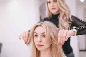 Free photo woman setting hair of girl in parlor