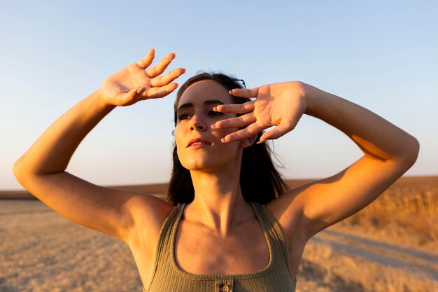 Woman shading her face from the sun while outdoors