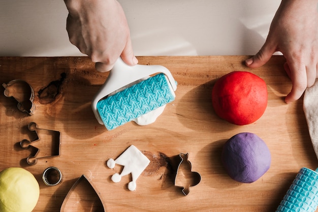 Free Photo woman shaping colorful plasticine on wood board