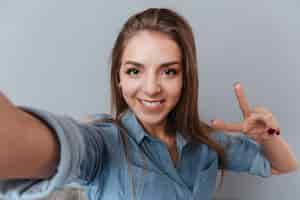 Free photo woman in shirt making selfie in studio