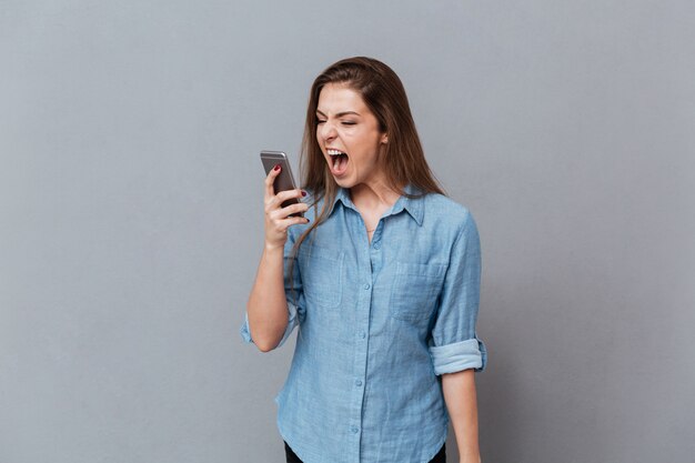 Woman in shirt screaming on phone