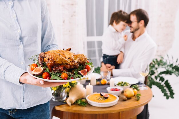 Woman in shirt standing with baked chicken