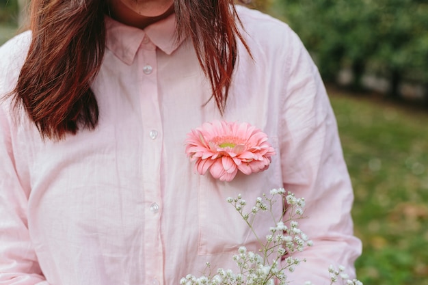 Woman in shirt with flower in pocket