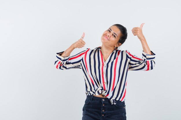 woman showing double thumbs up in shirt, skirt and looking glad