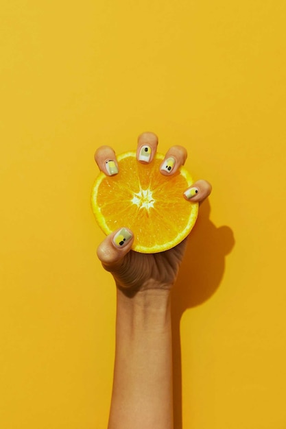 Free photo woman showing her nail art on fingernails with citrus