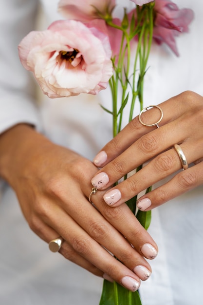 Woman showing her nail art on fingernails with flower