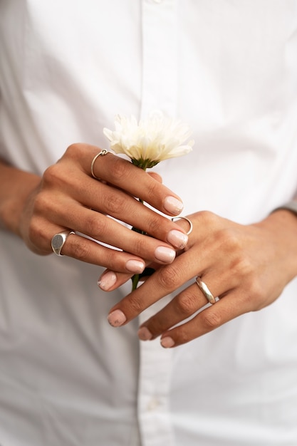 Woman showing her nail art on fingernails with flower