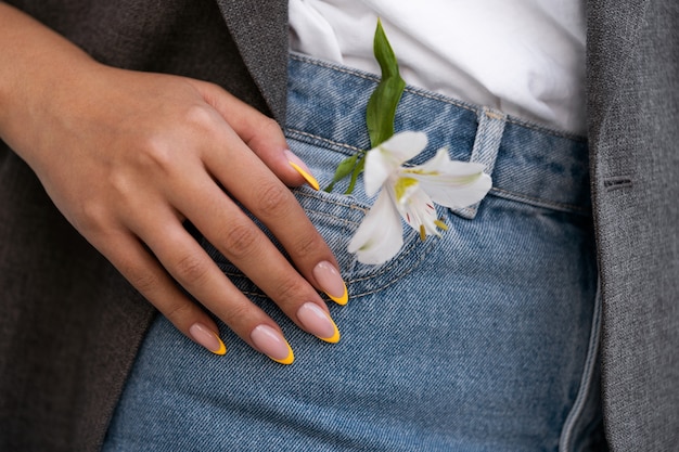 Woman showing her nail art on fingernails with flower