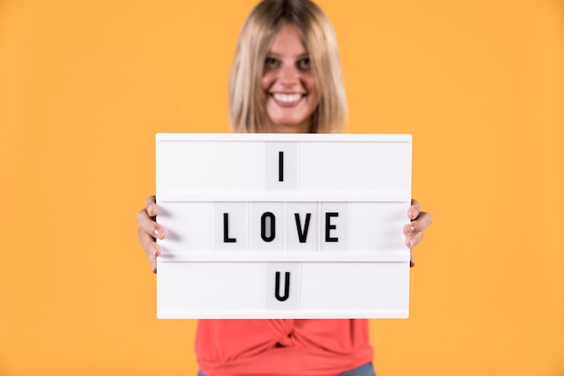 Free Photo woman showing i love you text on light box