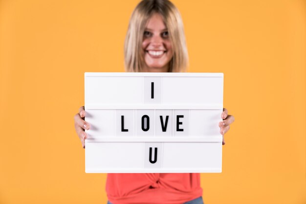 Woman showing i love you text on light box