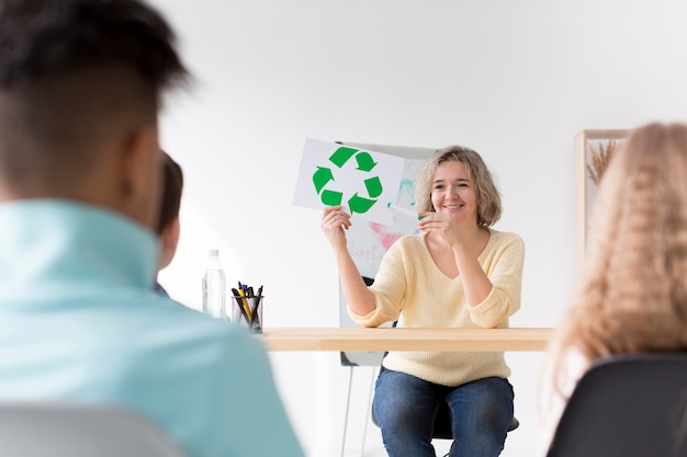 Free photo woman showing kids recycle sign