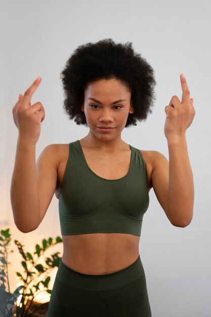 Woman showing middle finger while exercising