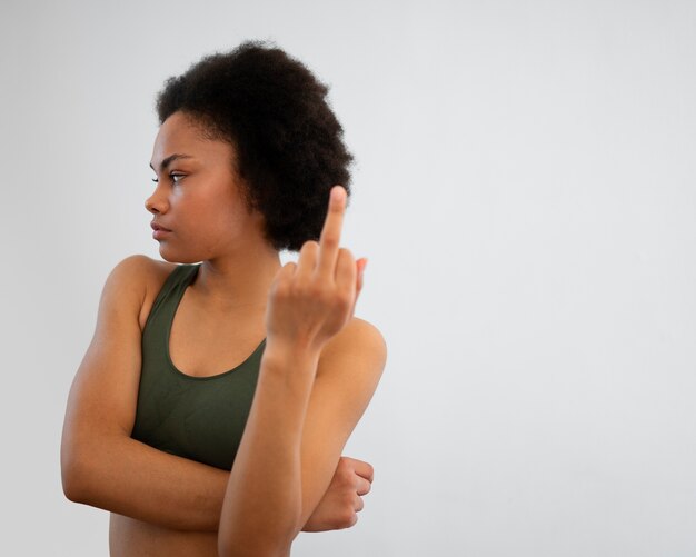 Woman showing middle finger while exercising