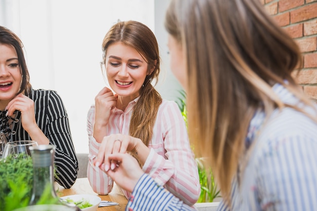 Woman showing ring to friends