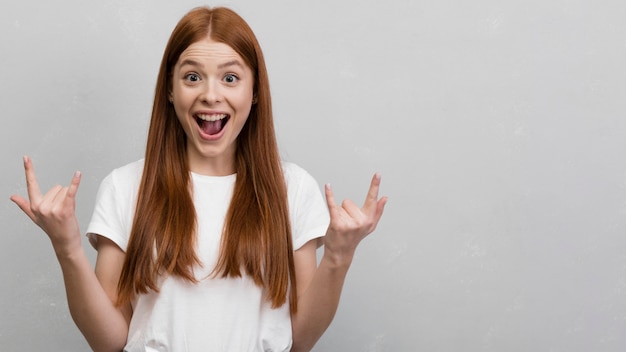 Free photo woman showing rock sign front view