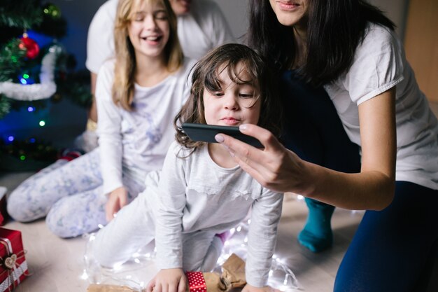 Woman showing smartphone to daughter