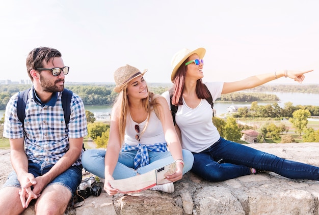 Free Photo woman showing something to her friends while hiking